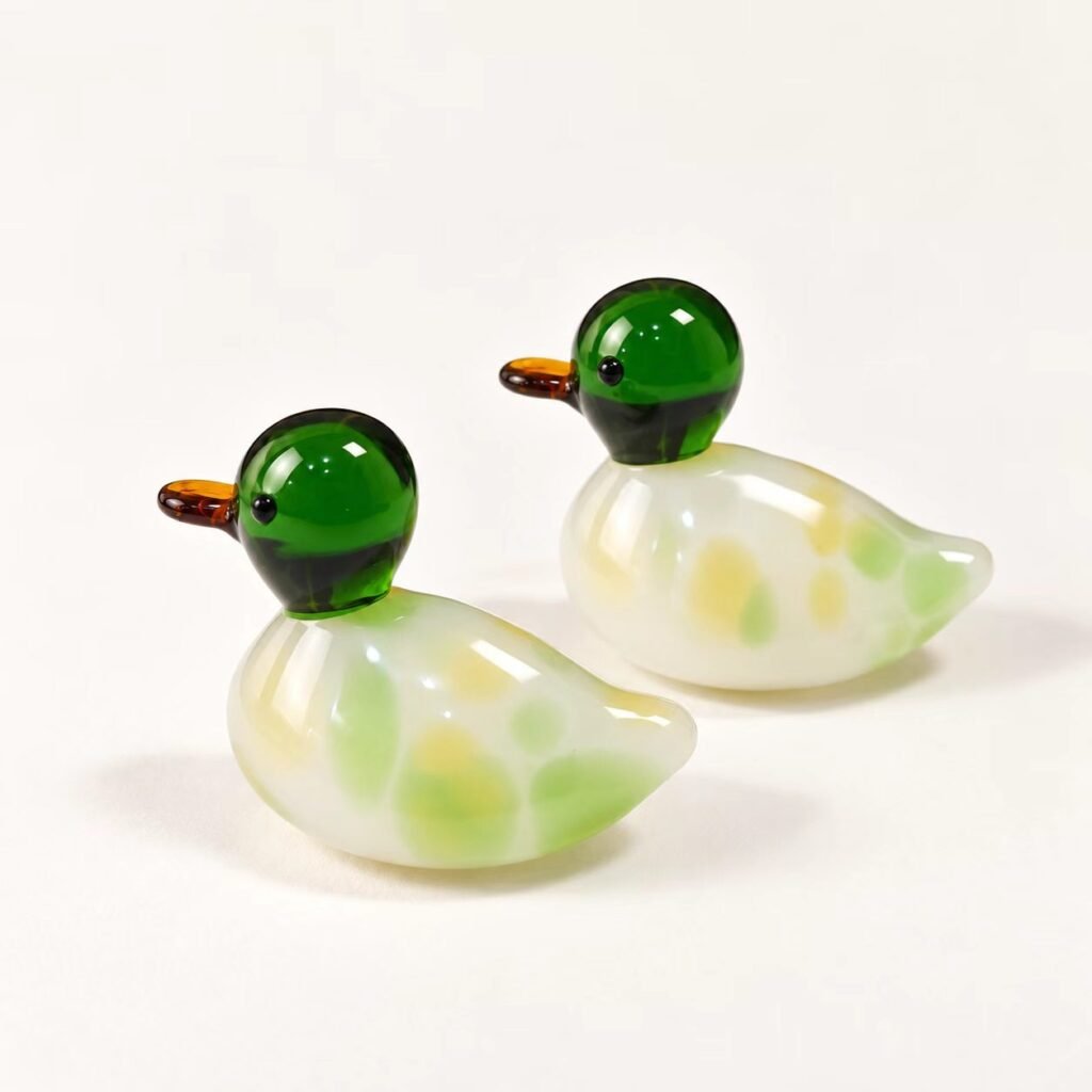 Pair of handmade glass ducks with green heads and soft yellow-green bodies